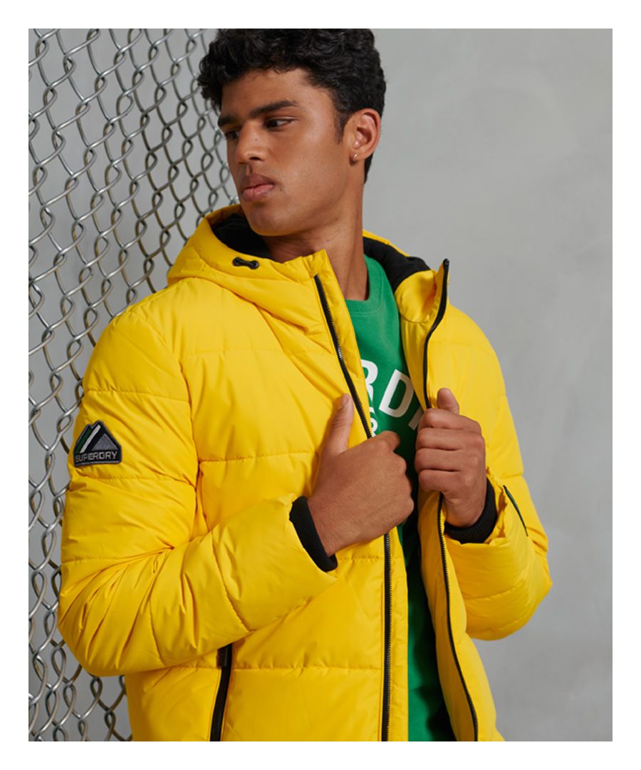 Need a jacket that's warm and practical, but sporty and stylish at the same time? Look no further with the Sports Puffer jacket, designed to look good and keep the cold out with its fleece lining.Zip fasteningBungee cord adjustable hoodZip fastened pocketsRibbed cuffsBungee cord adjustable hemFleece liningSingle internal pocketSignature logo patchRubber logo badgeThe padding in this jacket is 100% Recycled Polyester – each jacket contains up to 10 recycled bottles, this avoids these bottles being sent to landfill or polluting our oceans.