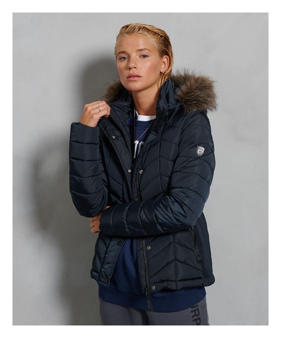 A classic Fuji, the Luxe Fuji Padded Jacket features 100% recycled polyester padding, designed to provide you with ultimate warmth and comfort this season. Being sustainably friendly never looked so good! Perfect for layering over a knit jumper with jeans to complete the look this season.Main zip and popper fasteningDetachable, bungee cord hoodFaux fur trimTwo external zip pocketsRecycled paddingElasticated rib side panelsElasticated cuffsSignature logo badgeThe padding in this jacket is 100% Recycled Polyester – each jacket contains up to 10 recycled bottles, this avoids these bottles being sent to landfill or polluting our oceans.
