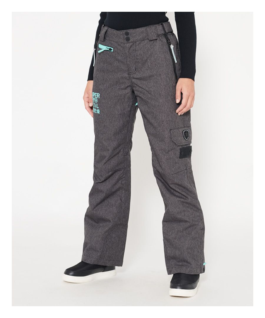 The Snow pants come with zip and popper fastening, waist adjuster straps, zipped hems with boot gaiters with clips and thigh vents to provide a comfortable fit when on the slopes. The pants also have a full insulated lining combined with fully taped seams and snow seals that help keep you warm and dry. The Snow pants have three front zipped pockets, two back pockets and a handy thigh pocket with hook & loop fastening. The front pockets have leg pulls to adjust the leg length. The pants are finished with branded zip pulls, a Superdry Ski tab on one back pocket, Superdry Snow prints on the upper thigh and back of the leg and a snowflake patch on the thigh pocket.Model wears: SmallModel height: 5’9” (175cm)