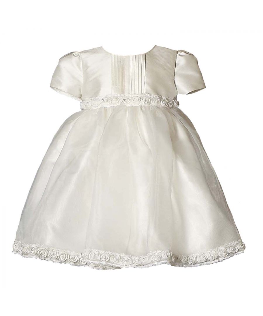 Heritage Special Occassionwear have brought back our every popular and one of our original styles - Daisy. It's a complete classic and one we keep getting asked about, we think because of its simple clean lines & pin tucks and its delicate trims that works perfectly with any accessory, to make a beautiful outfit for Bridesmaids, Flower girls or any little girls special occasion.\nIt's made in our 'Mock Silk' quality which no-one seems to be able to differentiate between real silk. In fact, at a recent sales show, we had the same dress in silk and mock silk...we asked members of the public to tell us which one they thought was real silk and everyone thought our mock silk was the real deal!  The skirt then has an overskirt in Organza with a floral and pearl trim.\nWe've added layers of net as an underskirt to give it real fullness and great twirlability, then fully lined it in 100% cotton so it's soft but more importantly better against the skin especially if your little one has sensitive skin.\nOuter - 100% polyester\nlining - 100% Cotton\nDry Clean or Hand Wash Only